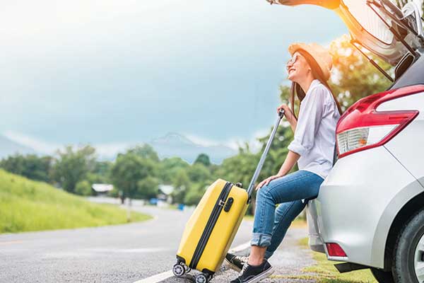 woman spending weekend on roadtrip with yellow luggage.